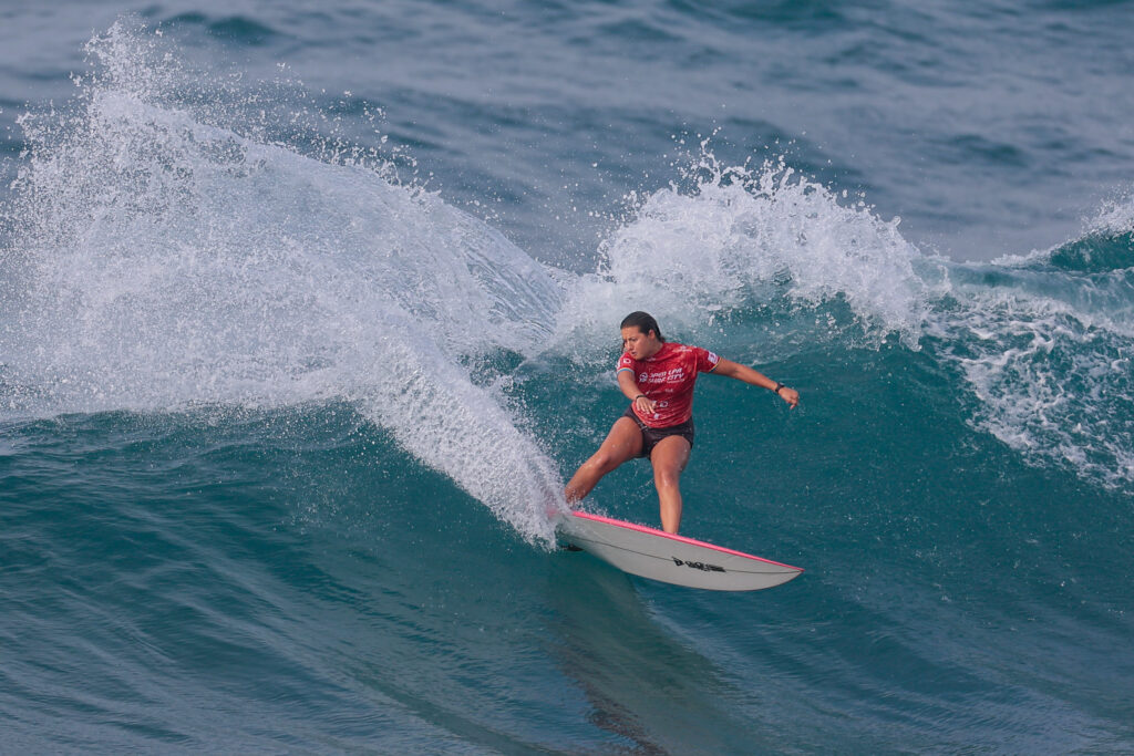 Surfista con licra roja trazando un giro en la ola de La Cícer, Las Palmas de Gran Canaria